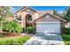 Two-story house with tan exterior, white garage door, and landscaped yard at 9083 Quail Creek Dr, Tampa, FL 33647