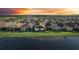 Beautiful aerial view of community, homes, and a tranquil lake surrounded by lush greenery at 4838 Sevilla Shores Dr, Wimauma, FL 33598