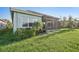 Lush green backyard with a screened-in lanai offers serene outdoor living at 4838 Sevilla Shores Dr, Wimauma, FL 33598