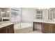 Bathroom features a soaking tub with dual sinks and modern vanity, creating a spa-like experience at 4838 Sevilla Shores Dr, Wimauma, FL 33598