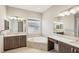 Bright bathroom with dual vanity, soaking tub, and modern fixtures for a relaxing retreat at 4838 Sevilla Shores Dr, Wimauma, FL 33598