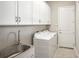 Bright laundry room features washer, dryer, cabinets, and sink at 4838 Sevilla Shores Dr, Wimauma, FL 33598