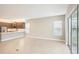 An open floor plan features a modern kitchen and bright living area with neutral tile flooring at 4838 Sevilla Shores Dr, Wimauma, FL 33598
