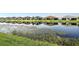 Idyllic pond reflecting beautiful homes, showcasing community's serene waterfront living at 4838 Sevilla Shores Dr, Wimauma, FL 33598