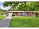 Brick house with driveway, grassy yard, and mature trees at 731 E Lumsden Rd, Brandon, FL 33511