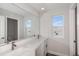 Bathroom featuring double sinks with quartz countertop and a view to tub and shower area at 10288 Surrey Rose Dr, San Antonio, FL 33576