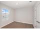 Bedroom with carpet, window, and a white door with silver hardware at 10288 Surrey Rose Dr, San Antonio, FL 33576