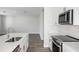 Well-lit kitchen with an island, stainless appliances, white cabinets, and wood-look floors at 10288 Surrey Rose Dr, San Antonio, FL 33576