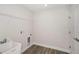 Laundry room with wood-look floors, sink, shelving and connections for a washer and dryer at 10288 Surrey Rose Dr, San Antonio, FL 33576