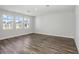 Inviting living room featuring durable laminate flooring, three large windows, and ample space for furniture at 10288 Surrey Rose Dr, San Antonio, FL 33576