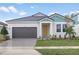 Exterior of charming one-story house with gray garage door and teal accents at 10317 Fieldstone Myrtle Way, San Antonio, FL 33576