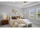 Inviting bedroom features a king-size bed, neutral colors, and natural light from the window at 9120 Warm Springs Cir, Parrish, FL 34219