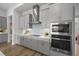 Modern kitchen with stainless steel appliances, range hood, and tile backsplash at 9120 Warm Springs Cir, Parrish, FL 34219