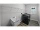 Well-lit laundry room equipped with modern washer, dryer, sink, and shelving at 9120 Warm Springs Cir, Parrish, FL 34219