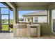 Outdoor kitchen features a built-in grill, mini fridge and counter space for entertaining at 9120 Warm Springs Cir, Parrish, FL 34219