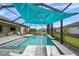 Covered pool and patio area featuring lounge chairs, an umbrella, and lush landscaping at 9120 Warm Springs Cir, Parrish, FL 34219