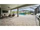Screened-in outdoor living area with a pool, seating, and an outdoor fan at 9120 Warm Springs Cir, Parrish, FL 34219