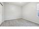 Bedroom featuring grey carpet and window with blinds at 8550 Creedmoor Ln, New Port Richey, FL 34654