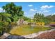 Serene backyard with a pond and waterfall feature, lush landscaping, and tropical plants at 4610 Duxberry Ln, Valrico, FL 33594