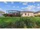 Spacious backyard with lush lawn, colorful flowerbeds, and a screened-in lanai for outdoor enjoyment at 5621 Rock Dove Dr, Sarasota, FL 34241
