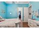 Bright blue bedroom with white wicker dresser and wood floors at 5621 Rock Dove Dr, Sarasota, FL 34241