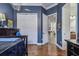 Blue bedroom with wooden flooring, white closet, leading to other rooms at 5621 Rock Dove Dr, Sarasota, FL 34241