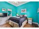 Comfortable bedroom featuring turquoise walls, wood floors, and a ceiling fan at 5621 Rock Dove Dr, Sarasota, FL 34241