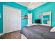 Inviting bedroom boasts turquoise walls, wood floors, and ample closet space at 5621 Rock Dove Dr, Sarasota, FL 34241