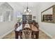 Formal dining room with elegant chandelier, decorative mirror, and view of the front yard through the window at 5621 Rock Dove Dr, Sarasota, FL 34241