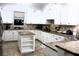 Kitchen with island, white cabinets, stone backsplash, and stainless steel appliances at 5621 Rock Dove Dr, Sarasota, FL 34241