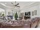 Expansive living room with a large leather sofa, tile floors, and backyard access at 5621 Rock Dove Dr, Sarasota, FL 34241