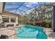 Screened-in pool with lush landscaping, offering a private and serene outdoor space at 5621 Rock Dove Dr, Sarasota, FL 34241