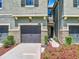 Two-car garage with gray doors and landscaping at 11650 Cambium Crown Dr, Riverview, FL 33569