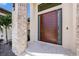 Modern entryway with a sleek wood door and stone columns at 9276 Starry Night Ave, Sarasota, FL 34241