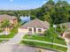 Aerial view of a landscaped home with a lake view, well-manicured lawn, and inviting curb appeal at 10918 Rain Lilly Pass, Land O Lakes, FL 34638