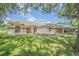 Tan house with burgundy accents, arched windows, and a two-car garage at 8360 Palm Lakes Ct, Sarasota, FL 34243