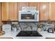 Kitchen features granite countertops, a cooktop, microwave, and updated cabinetry at 1816 Union St, Clearwater, FL 33763