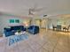 Open living room and dining area with blue sofas and light tile floors at 3035 Countryside Blvd # 14B, Clearwater, FL 33761