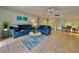 Open living room and dining area with blue sofas and light tile floors at 3035 Countryside Blvd # 14B, Clearwater, FL 33761