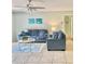 Living room with blue sofas, coffee table, and ceiling fan at 3035 Countryside Blvd # 14B, Clearwater, FL 33761