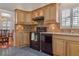 View of the kitchen with wood cabinets, black appliances, and tile backsplash at 9132 Bassett Ln, New Port Richey, FL 34655