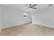 Large bedroom with wood-look floors, ceiling fan and neutral walls at 8402 Bedford Ln, Tampa, FL 33615