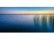 Serene lake view featuring tranquil water, a vibrant sunset, and native Florida grasses at 10603 Low Oak Ter, Thonotosassa, FL 33592