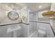 Cozy bathroom with pedestal sink, decorative mirror, tiled shower, and black and white tiled floors at 1661 Watermark Ne Cir, St Petersburg, FL 33702