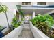 Inviting front entrance with mature tropical landscaping and a decorative glass door at 1661 Watermark Ne Cir, St Petersburg, FL 33702