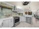 Modern kitchen features stainless appliances, white cabinets and marble backsplash at 1661 Watermark Ne Cir, St Petersburg, FL 33702