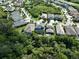 An aerial view of a neighborhood with a light blue house and lush green surroundings at 5112 Coastal Scene Dr, Apollo Beach, FL 33572