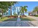 Two-story light blue house with palm trees, walkway, and well-maintained landscaping at 5112 Coastal Scene Dr, Apollo Beach, FL 33572