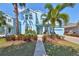 Two-story light blue house with palm trees and well-manicured landscaping at 5112 Coastal Scene Dr, Apollo Beach, FL 33572