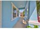 Charming light blue front porch with white columns and landscaping at 5112 Coastal Scene Dr, Apollo Beach, FL 33572